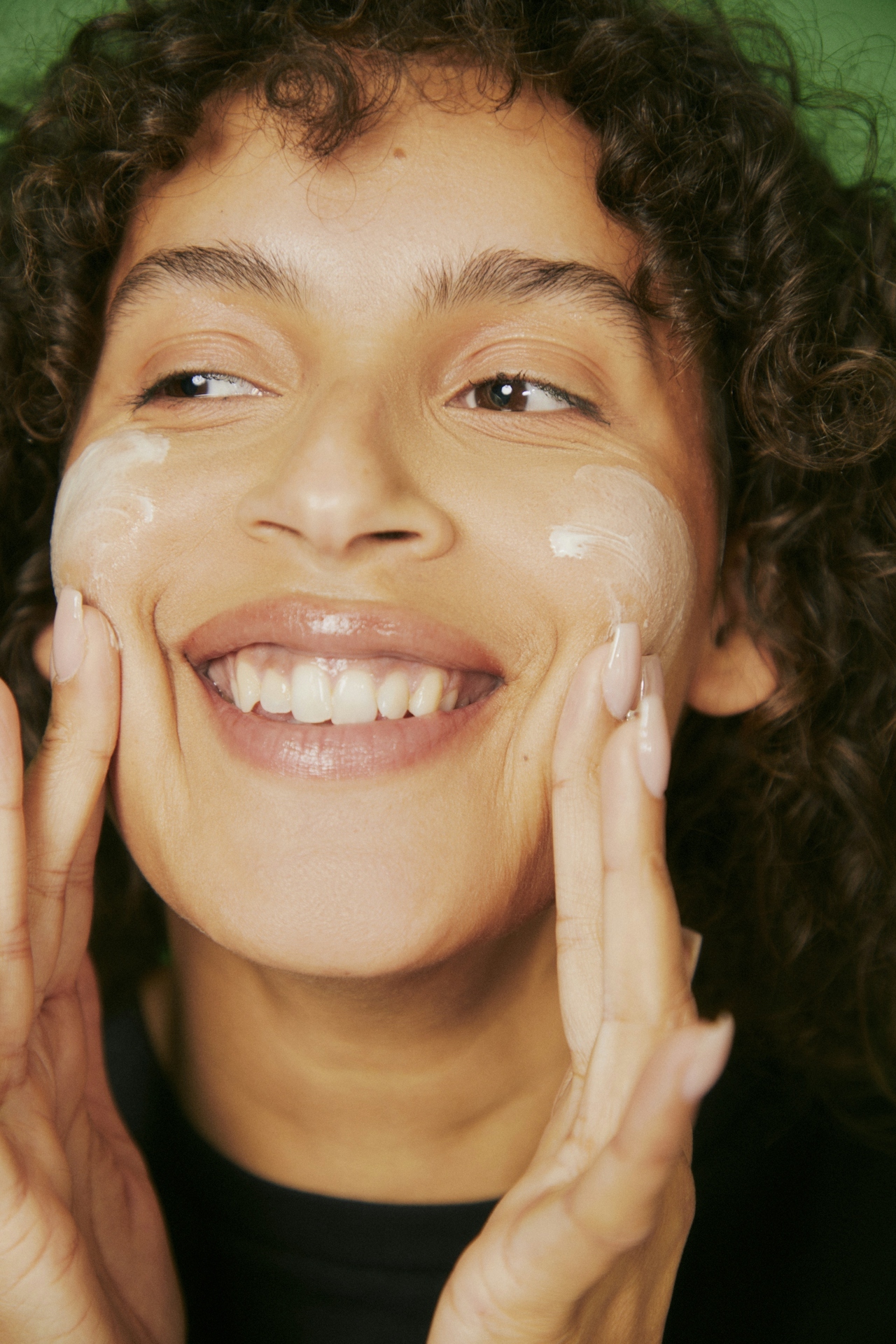 woman rubbing moisturizer onto face