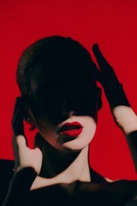 red background with woman in shadows with red lipstick model